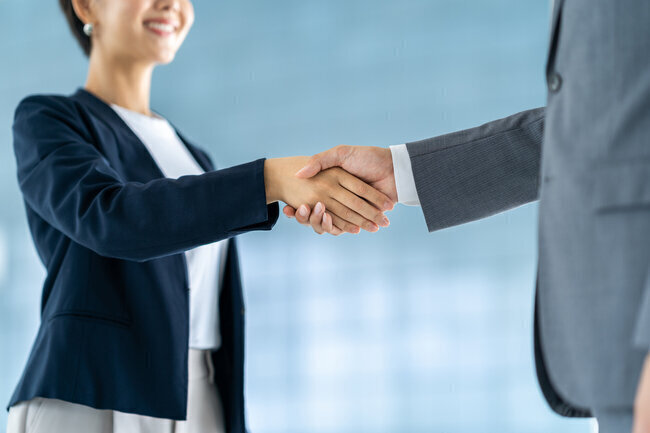 契約で握手する人々の画像